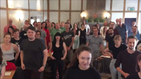 A GIF showing lots of 啄木鸟系列 Pi colleagues smiling, saluting and clapping enthusiastically