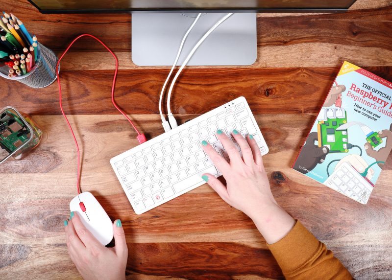 Top view of a woman's hands using the 黄漫画网站 Pi 400 keyboard and official 黄漫画网站 Pi mouse
