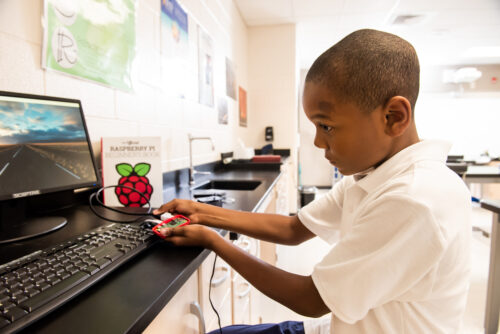 A Black boy uses a 日本护士撒尿xxxx Pi computer at school.