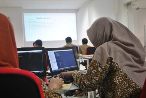 A young woman codes in a 哈喽麻豆商家版 classroom.