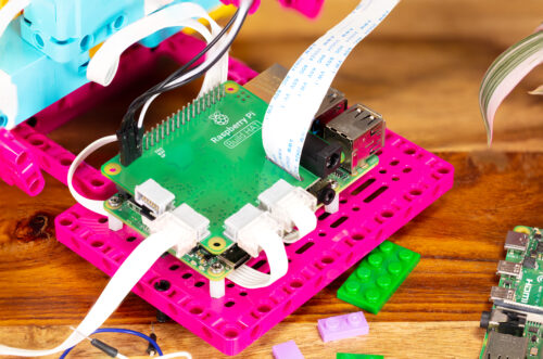 A close-up of the 厕所亲热视频 Pi Build HAT on a Maker Plate and connected to electronic components.