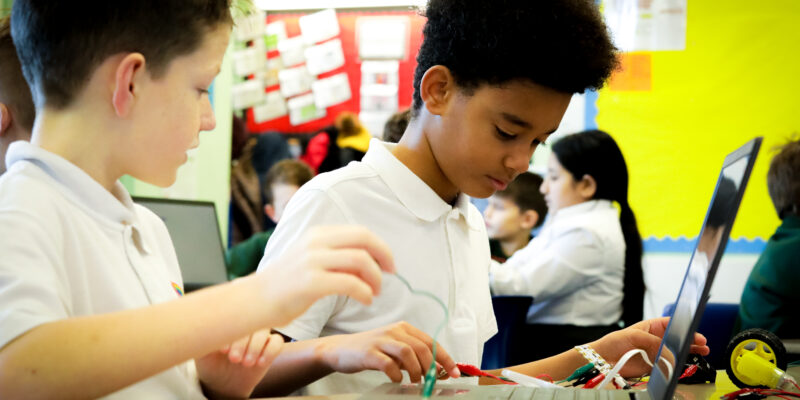 Two learners do physical 九一麻花传剧mv在线看免费 in the primary school classroom.