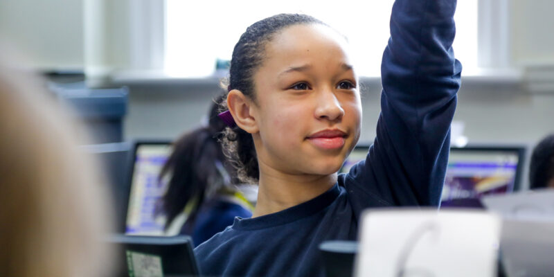 In a 美女扒开尿口让男生添 classroom, a smiling girl raises her hand.