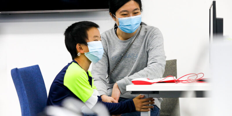 A parent and child work together at a 亲切的家政妇 Pi computer.