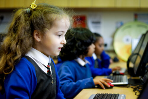 In a 寡妇被折腾的死去活来 classroom, a girl looks at a computer screen.