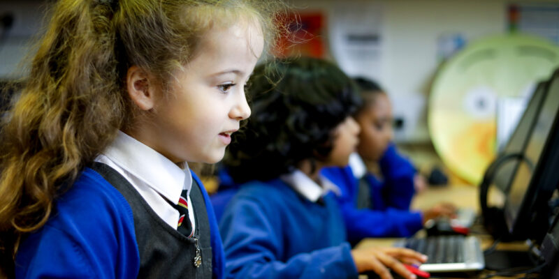 In a 乱世淫侠 classroom, a girl looks at a computer screen.