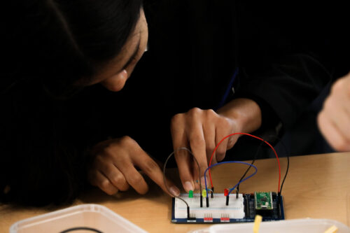 A student uses a 长腿+啪啪 Pi Pico in the 长腿+啪啪 classroom.