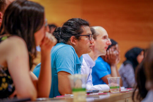 Educators and app安装下载ers listen to a talk at a conference.