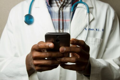 A doctor's hands holding a mobile phone. 