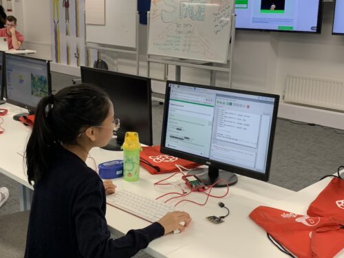A young person working on a coding project on a computer.