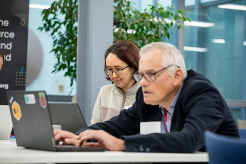 Two educators at a desk using their computers. 