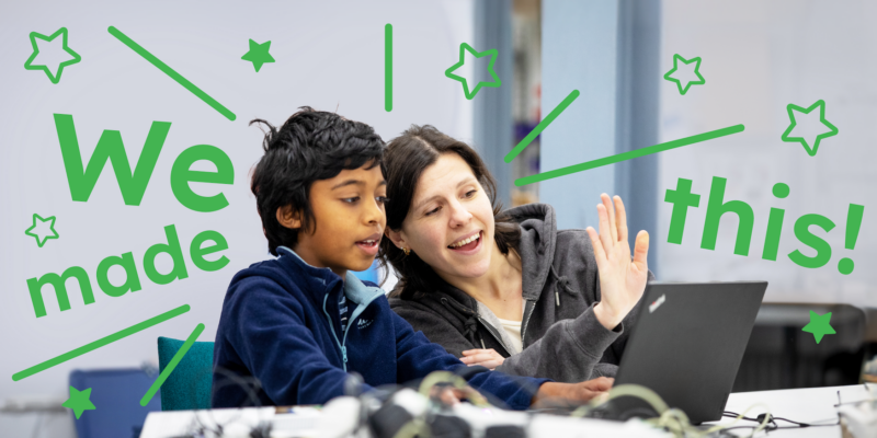 A mentor and a young tech creator at a computer at a Code Club session.