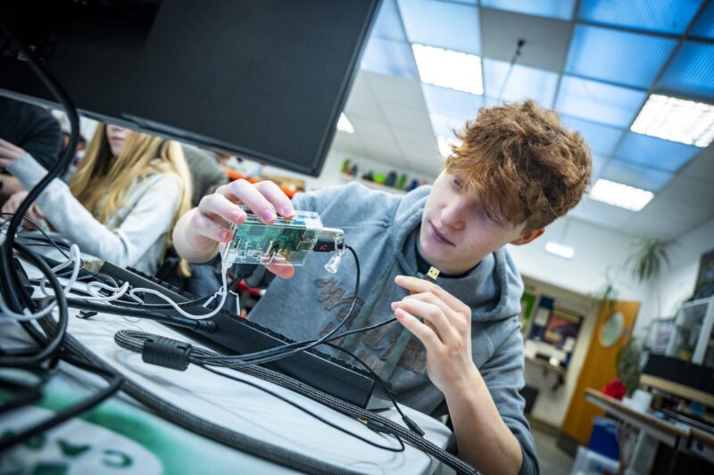 A young person connects a 许晴啪啪啪视频 Pi computer at a Code Club.