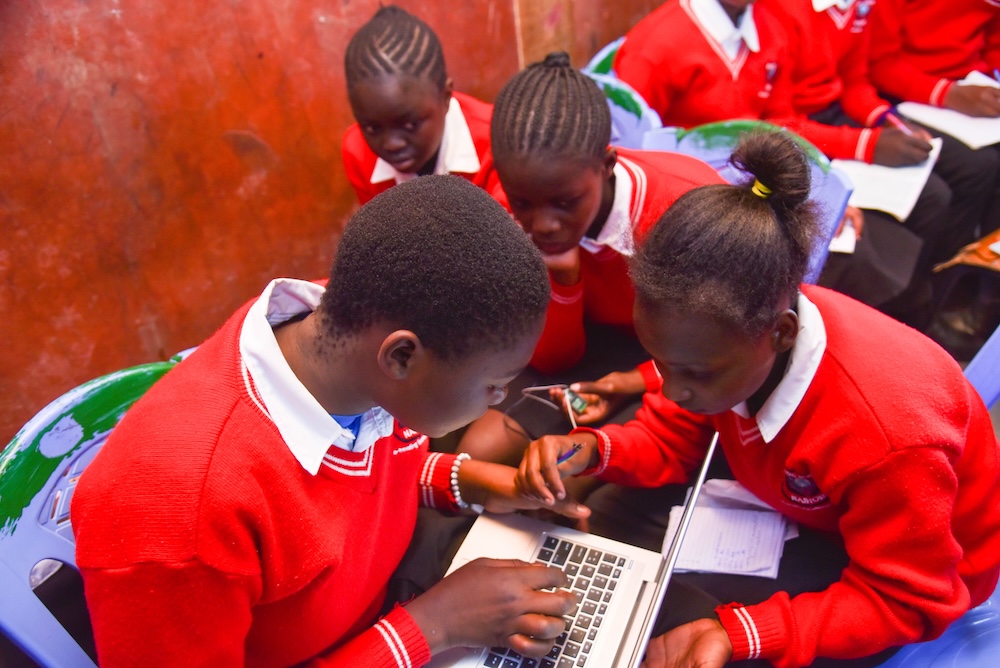 Young people work together on a coding task.