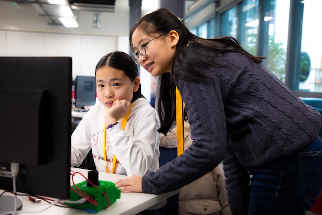 Two students working together to write Python code for their Mission Space Lab entry.

