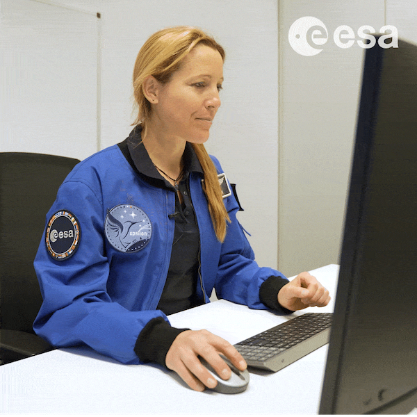 ESA Astronaut Sophie Adenot smiling while coding her Mission Zero entry on a laptop.