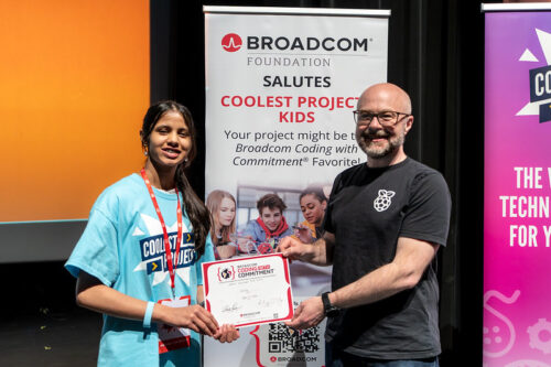 Two people holding a certificate in front of a Broadcom banner.